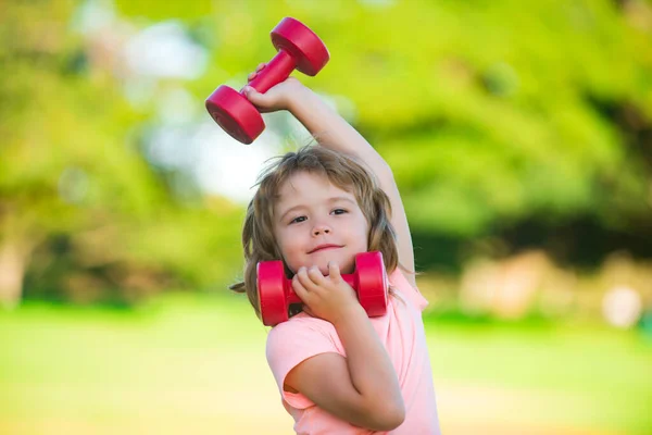 Parkta çocuk antrenmanı. Çocuklar spor yapar. Çocuk halterle egzersiz yapıyor. Dambılı açık havada spor ve fitness çocuğu. Çocuklar spor yapar. Çocuklar aktif, sağlıklı bir yaşam tarzı. Sağlıklı aktiviteler, çocuk yaşam tarzı. — Stok fotoğraf