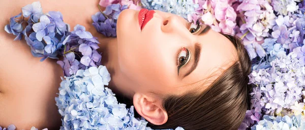 Makeup cosmetics and skincare. Nature beauty. Woman lying on flowers. Unity with nature. Blossom. Girl with hydrangea flowers. Banner spring design, advertising for website header. — Stock Photo, Image