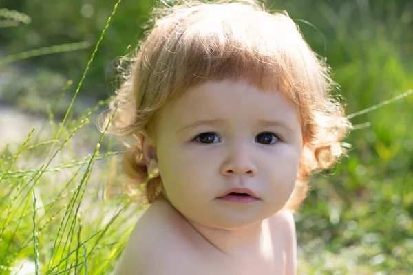 Happy baby at the park. Baby face close up. Funny little child closeup portrait. Blonde kid, emotion face. — Fotografia de Stock