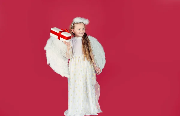 Regalo de San Valentín emociones infantiles. Pequeña chica Cupida. Ángel niño con regalo. Un angelito con alas blancas sostiene el regalo. Tarjeta de felicitación del principito. Día de San Valentín. — Foto de Stock