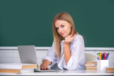 Sevimli bir genç kız, okul öğrencisi notlar yazıyor, internetten video izliyor, bilgisayardan öğreniyor, sınıfta oturuyor, uzun mesafe öğrenme kursuna gidiyor, bilgisayar konferansına katılıyor. Uzaklık öğrenimi.