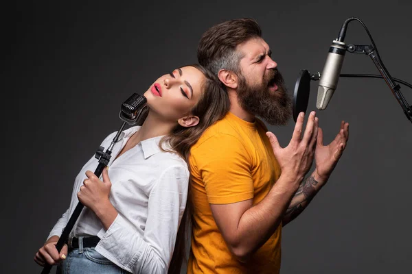 Zpívající muž v nahrávacím studiu. Výrazný pár s mikrofonem. Karaoke duet signers, hudební zpěvák. — Stock fotografie