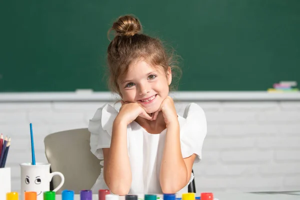 Vicces iskolás lány arc. Gyermek lány rajz színező tollak festék. Aranyos kislány portréja, aki boldogan mosolyog, miközben élvezi a művészetet és a kézműves leckét az iskolában.. — Stock Fotó