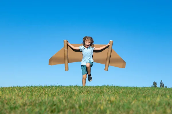 Menino criança com asas no céu imagina um piloto e sonhos de voar. — Fotografia de Stock