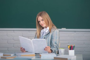 Lisede ya da üniversitede ders hakkında kitap tutan kız öğrenci.