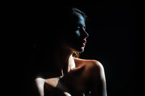 Gyengéd lány, gyengédség. Elegáns fiatal nő pózol fekete háttérrel. Fény és árnyék. Egy szépséges nő arcképe. — Stock Fotó