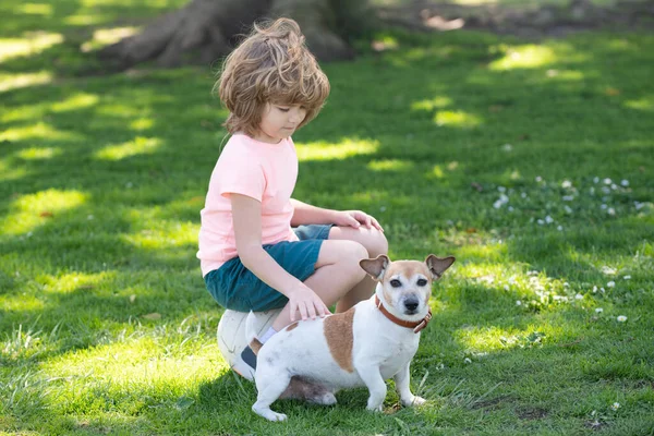 Portrait d'un enfant garçon joue avec un chien en plein air. Enfant caresse chien. — Photo
