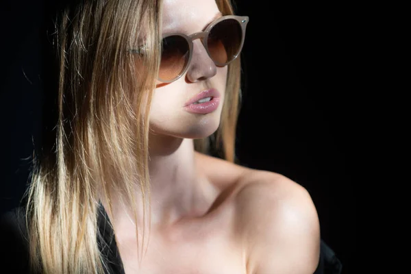 Portrait of beautiful woman in sunglasses model looking seductive and sensual. Beauty face with dramatic studio light isolated on black. — Fotografia de Stock