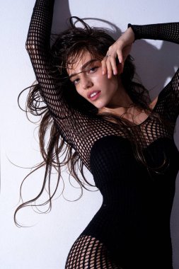 Şehvetli manken. Tecrit edilmiş stüdyo geçmişi olan modaya uygun bir kadın. Genç, zarif bir kadının moda portresi, stüdyo fotoğrafı. Moda pozisyonunda güzel bir genç bayan..
