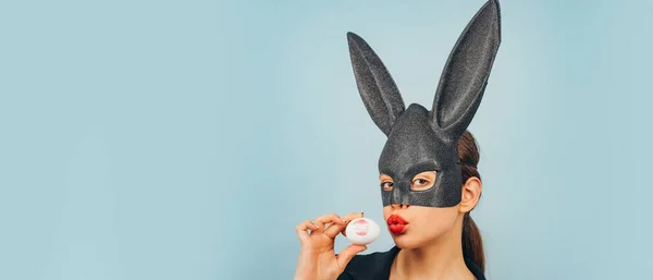 Banner de Páscoa com mulher coelhinha. Menina com orelhas de coelho de renda. Coelhinha da Páscoa, coelho e menina. Batom beijo impressão no ovo de Páscoa. — Fotografia de Stock