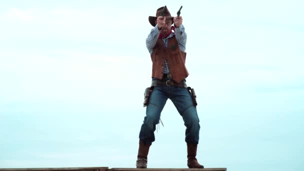 Sheriff in cowboy hat with vintage pistol revolver and marshal ammunition. American gunslinger on wild west, guy shooting with gun revolver weapon. — Vídeo de Stock