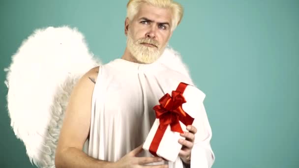 Funny angel cupid valentin with gift. Funny bearded man with feathers wings of Cupid Valentines Day. Humor comical concept. — Wideo stockowe