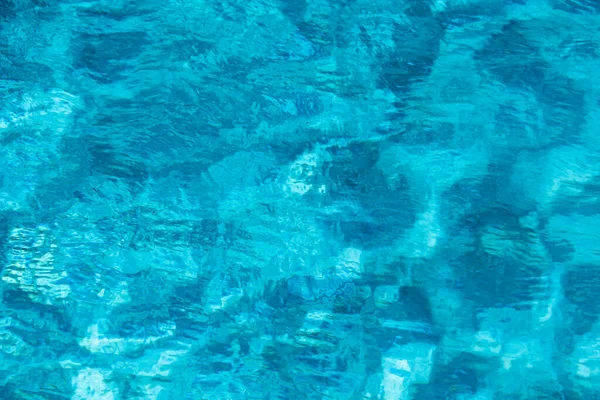 抽象的なリップル波とスイミングプール内の明確なターコイズブルーの水面、背景と抽象的なデザインのための青い波. — ストック写真