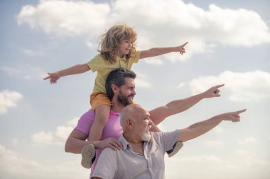 Soy ağacı. Baba ve oğul büyükbabayı işaret ettiği için çok heyecanlıydılar. El işaretleri noktası. Mutlu jenerasyon dilsiz üç nesil erkek aile portresi.