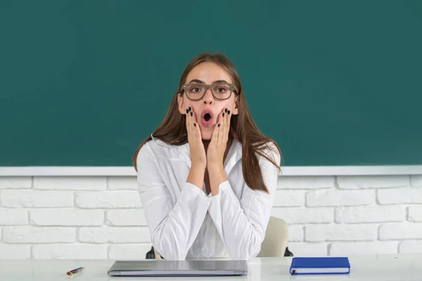 Retrato de una joven, segura y atractiva estudiante que estudia en el aula de la escuela. La secundaria sorprendió al estudiante en el aula. Sorprendida chica de la escuela. — Foto de Stock