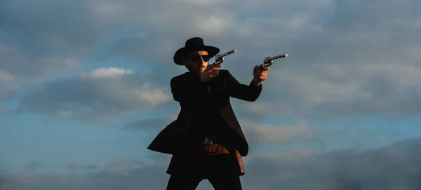 Американский ковбой стреляет. Красивый жестокий западный парень. Шериф с пушками Дикого Запада, винтажным пистолетом и боеприпасами маршала. Американский западный. Дикий Запад с ковбоем. — стоковое фото