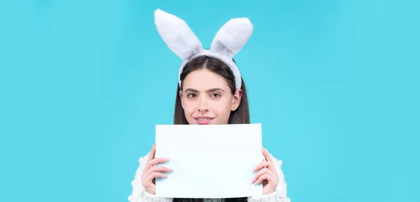 Easter banner with bunny woman. Portrait of Easter bunny woman hold paper. Model dressed in costume Easter bunny on blue background isolated. Bunny girl celebrating easter. — Stock Photo, Image