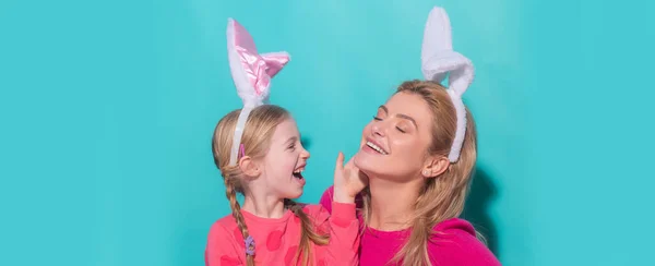Happy mother and child daughter celebrating Easter. Cute little girl with funny face in bunny ears laughing, smiling and having fun. Easter banner with copy space. — Foto Stock