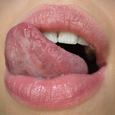 Seksi dilli. Yakın plan mükemmel doğal dudak, dili çıkmış dişi ağız. Tombul seksi dolgun dudaklar. Makro yüz ayrıntıları.