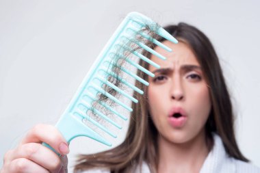 Saçını taramış, saçları sorunlu bir kadın. Saç dökülmesi stresli kadın ve kel problemleri.