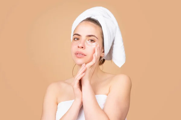 Gezichtsbehandeling. Cosmetologie schoonheid en spa. Meisje van toepassing huidverzorgingscrème op gezicht, vrouw wrap handdoek op het hoofd zet gezichtscrème op het doen van ochtend gezonde huid. — Stockfoto