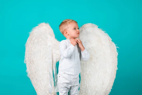 Beautiful little blonde angel boy. Valentine card. Child with angelic character. Toddler boy wearing angel costume white dress and feather wings. — Foto Stock