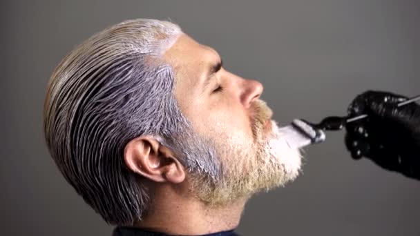 Coloração do cabelo no processo de cor cinza. Processo de um tipo com barba e bigode tingidos. Os homens barbudos do Hipster pintam-lhe o cabelo. Cabelo louro tingido para um hipster barbudo. — Vídeo de Stock