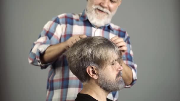 Profesionální kadeřník česání muž vlasy v salonu krásy, detailní záběr. — Stock video