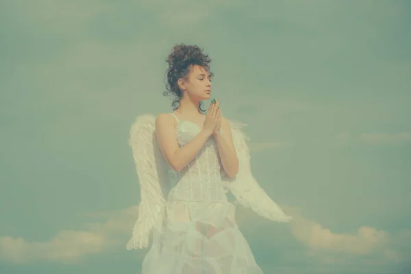 Ángel de San Valentín adolescente rezando. Angel adolescente en el cielo. Chica ángel adolescente con alas, espacio de copia en el cielo. — Foto de Stock