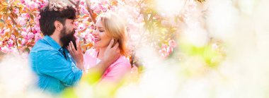 Aşık bahar çifti, Banner. Bahar Parkı 'nda yürüyen ve güzel bahar çiçeklerinin tadını çıkaran çift. Mutlu Paskalyalar. Bahar mevsiminde öpüşen çift. Yakın plan portresi..