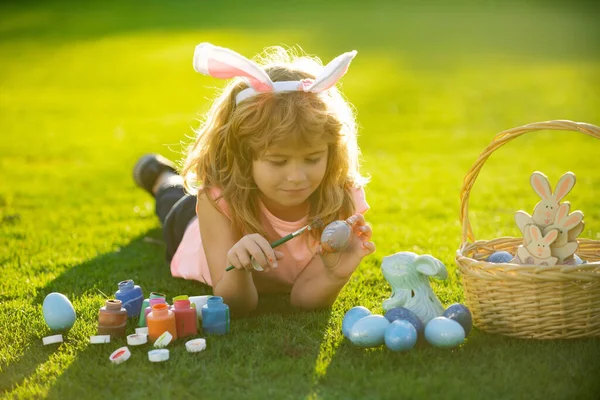 Kinderen vieren Pasen. Pasen kinderen met konijnenoren en op gras achtergrond. — Stockfoto