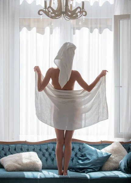 Back view of sexy girl resting in the luxury bedroom an easy morning. Attractive sensual woman relaxing wearing bathrobes and towels in hotel room. Lovely tenderness body. — Stockfoto