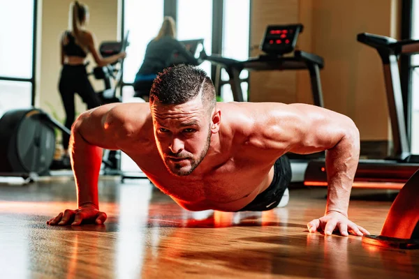 Fit man. Young muscular man with naked torso working out in gym. Sport man doing push ups exercise, pushup crunch. Fitness sports concept. — Stockfoto