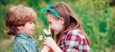 Bahar çocuğu suratlı pankart. Birbirini seven küçük bir çift birbirinin yüzüne üflüyor..