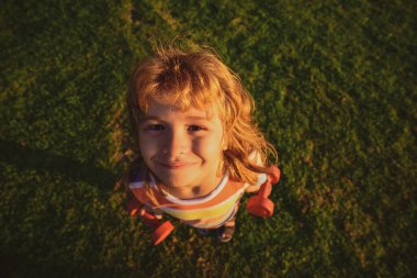 Komik çocuk suratı. Dambılı çocuk. Geniş açı. Spor antrenmanı ve insanların sağlığı.