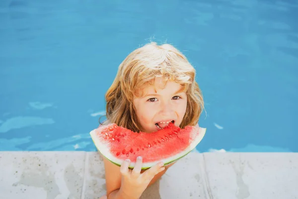 Lindo niño en la piscina comiendo sandía. Disfruta comiendo frutas tropicales. Concepto de niños de verano. Feliz infancia.. — Foto de Stock