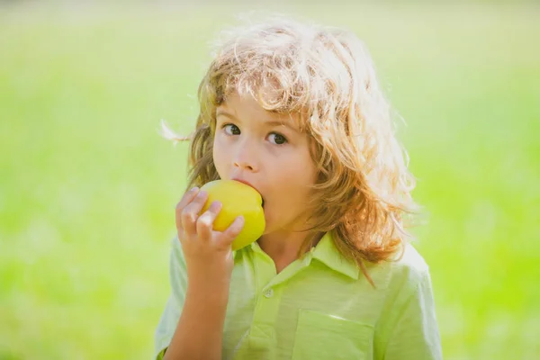 Jovem rapaz do campo está comendo uma maçã em um pomar de maçã ou fazenda. — Fotografia de Stock