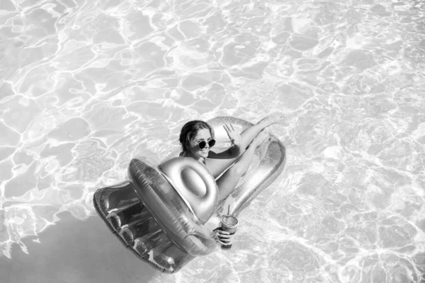 Счастливая женщина в купальнике. Девушка на летних каникулах. Женщина в бассейне на надувном матрасе. — стоковое фото