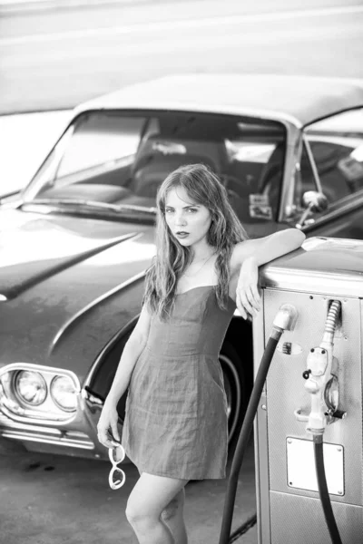 Красный ретро автомобиль. Староамериканская машина. Девушка с заправки. Женщина заправляет машину. — стоковое фото