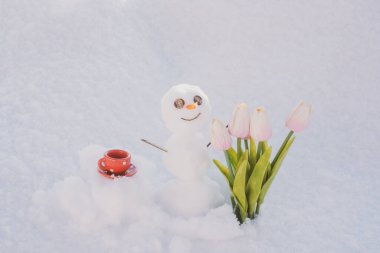 Merhaba ilkbahar, güle güle kış. Kahve fincanlı kardan adam. Çiçekli kardan adam.