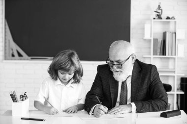 Okuldaki mutlu çocuk. Öğretmenin öğrenmesine yardım et. Eğitim, öğretmenlik, ilkokul