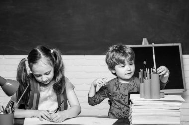 Okula dönüyoruz. Okul sınıfında kara tahta yakın çocuk. Komik küçük çocuk tahta arka planda eğlenmek.