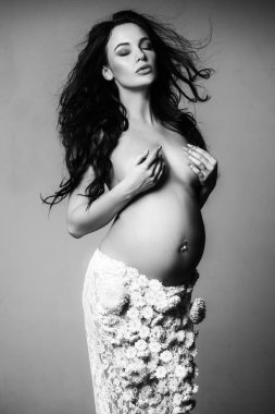 Yaşam beklentisi. Sevgi. Bahar çiçeği etekli güzel hamile kadın. Müstakbel annenin bebeği içeride. Kadın sağlığı. Koca göbekli kız. Hamilelik. Doğum hazırlığı. beklenti konsepti