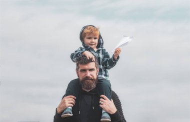 Babalar günü. Baba ve oğul parkta. Baba ile sevimli çocuk açık oynuyor. Çocuk babasının omuzlarında oturuyor. Baba, oğlunu parkta geri götürmeyi. Hayal.