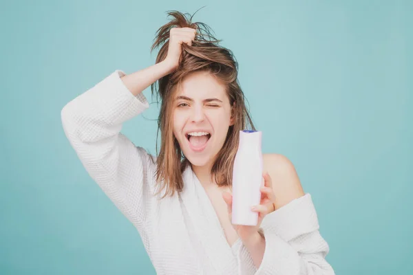 Mädchen, die Haarspülung anwenden. Frau berührt ihr Haar. Frau hält Flaschenshampoo und Conditioner in der Hand. — Stockfoto