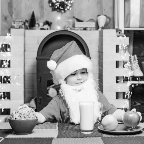 Weihnachtskind. Erntedank und Weihnachten. Weihnachtsmann. Weihnachtsmann-Kind isst Kekse und trinkt Milch. — Stockfoto