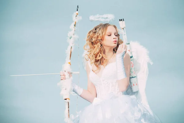 Toddler girl wearing angel costume white dress and feather wings. Cherub girl. Pretty teen girl. little Cupid girl aiming at someone with an arrow of love — 图库照片