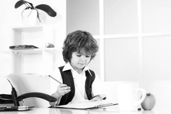 小さな少年実業家が書類に注意を払ってる。退屈な仕事だ。若い実業家. — ストック写真
