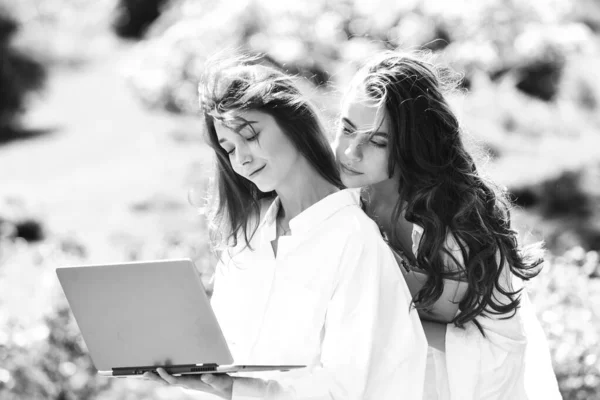 Estudantes universitárias no campus ao ar livre. Educação, campus, amizade e conceito de pessoas - grupo de estudantes adolescentes felizes com notebook . — Fotografia de Stock