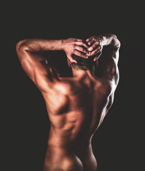 Strong Athletic Man showing his perfect back isolated on black background. Naked man posing in the studio on a dark background. Naked bodybuilder back. Its great. — Stock Photo, Image